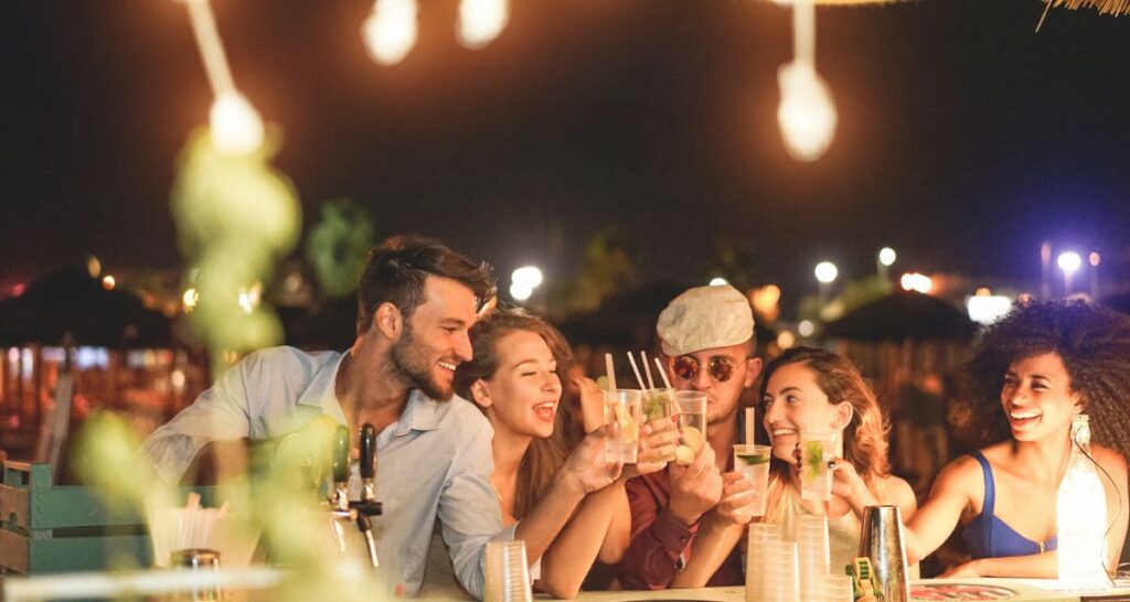 Two men and three women enjoying their drinks in a beach bar